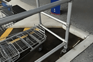 A metal pipe sleeve connector in a trolley bay, used to protect shopping trolleys in a shopping mall.